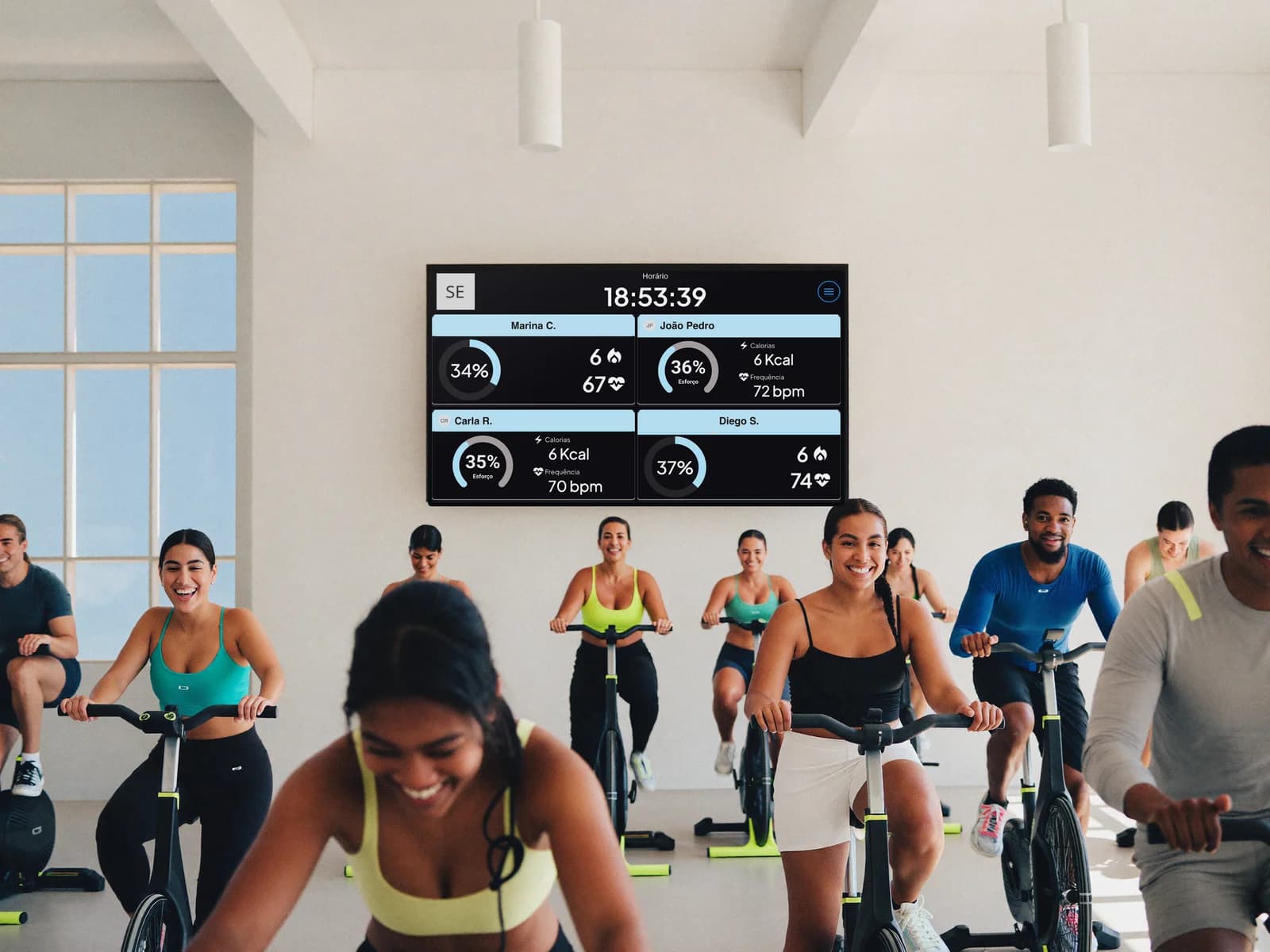 Aula coletiva com a TV do Vektor Pulse exibindo os dados de frequência cardíaca de cada aluno em tempo real